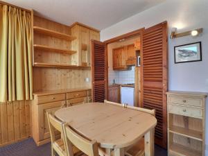 uma cozinha com armários de madeira e uma mesa de madeira em Appartement Méribel, 2 pièces, 4 personnes - FR-1-182-7 em Méribel