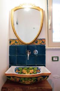 een badkamer met een spiegel en een wastafel bij DAI MORI in Palermo