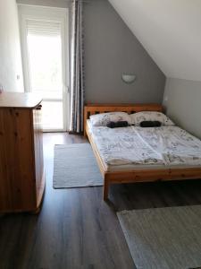 a bedroom with a bed and a large window at Családbarát apartman in Vonyarcvashegy