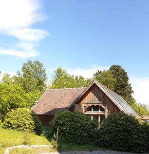 una casa de madera con techo y algunos arbustos en Ferienhaus auf 2 Etagen mit überdachter Terrasse, en Graal-Müritz