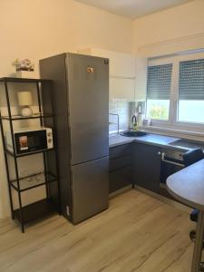 een keuken met een roestvrijstalen koelkast en een wastafel bij KE-TO Zagreb Airport Rooms in Velika Gorica