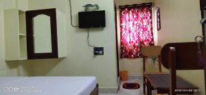 a room with a bed and a tv on the wall at Decent residency in Kākināda