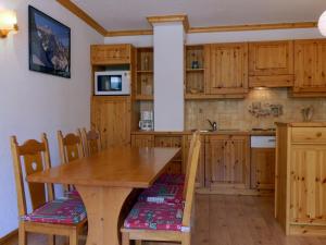 - une cuisine avec des placards en bois, une table et des chaises en bois dans l'établissement Appartement Méribel, 2 pièces, 5 personnes - FR-1-182-5, à Méribel