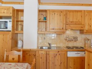 una cocina con armarios de madera y fregadero en Appartement Méribel, 2 pièces, 5 personnes - FR-1-182-5, en Méribel