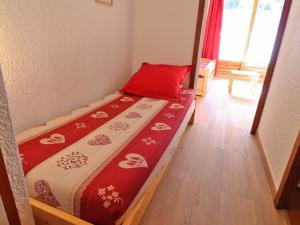 a small bedroom with a bed with a red pillow at Studio Méribel, 1 pièce, 3 personnes - FR-1-182-83 in Méribel