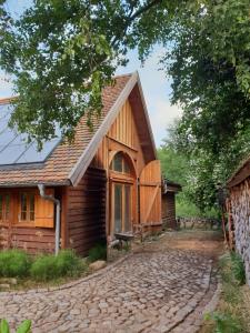 una casa de madera con una carretera de piedra delante de ella en Ferienhaus auf 2 Etagen mit überdachter Terrasse, en Graal-Müritz