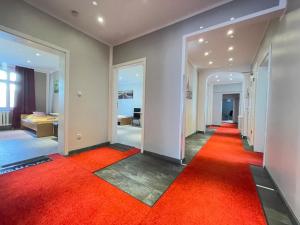a hallway with an orange carpet and a room at MOTEL DARIA Hennigsdorf Berlin in Hennigsdorf