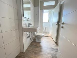 La salle de bains est pourvue d'un lavabo et de toilettes. dans l'établissement MOTEL DARIA Hennigsdorf Berlin, à Hennigsdorf