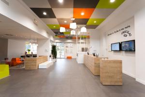 un hall d'un magasin avec un plafond coloré dans l'établissement ibis Styles Nancy Sud, à Houdemont