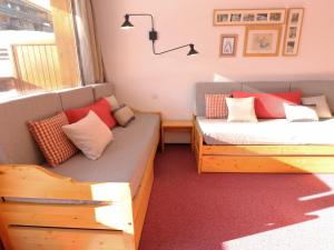 Cette chambre comprend deux lits et un canapé avec des oreillers. dans l'établissement Appartement Méribel, 2 pièces, 5 personnes - FR-1-182-162, à Méribel