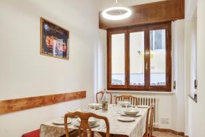 une salle à manger avec une table et des chaises et une fenêtre dans l'établissement Keith Haring Cozy Apartment, à Pise