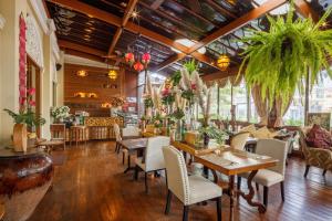 a restaurant with tables and chairs and plants at Khum Phaya Resort & Spa Boutique Collection in Chiang Mai