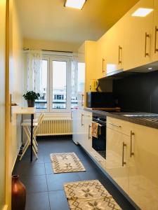 a kitchen with a counter and a table and a window at Superbe T2 tout équipé Aéroport Genève Tram 14 in Meyrin