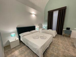 um quarto de hotel com duas camas e duas mesas em Donna Grazia Relais em Gallipoli