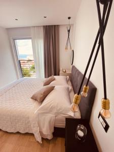 a bedroom with a white bed with a window at Mediteran in Tučepi