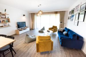 a living room with a blue couch and chairs at Silver Mountain Panoramic View C48 in Poiana Brasov