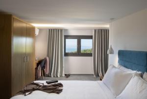 une chambre d'hôtel avec un lit et une fenêtre dans l'établissement Terra Olivia Luxury Villas and Suites, à Paliouri