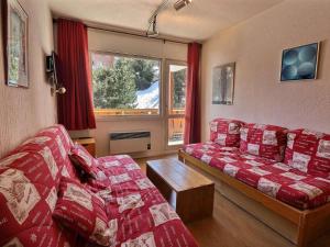 a living room with two red couches and a window at Appartement Méribel, 2 pièces, 5 personnes - FR-1-182-66 in Méribel