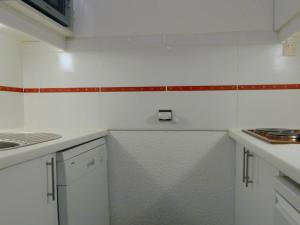 een keuken met witte werkbladen en rode en witte tegels bij Appartement Méribel, 2 pièces, 6 personnes - FR-1-182-59 in Méribel