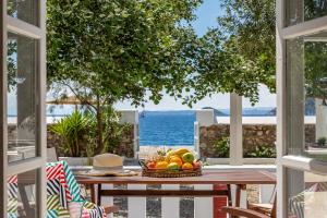 - une table de pique-nique avec une corbeille de fruits sur la terrasse dans l'établissement PSARIANOS BEACHFRONT APARTMENTS, à Panormos Skopelos