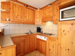 cocina con armarios de madera y microondas en Appartement Méribel, 2 pièces, 5 personnes - FR-1-182-160, en Méribel