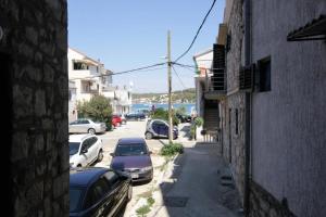 an alley with cars parked on the side of a building at Holiday house Ljubica Tisno in Tisno