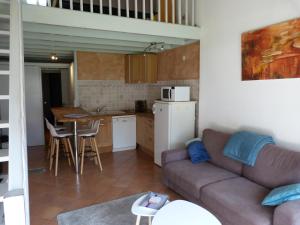 a living room with a couch and a kitchen at Appartement LARUNS 2 à 4 personnes in Laruns