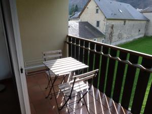 uma varanda com duas cadeiras e uma mesa em Appartement LARUNS 2 à 4 personnes em Laruns