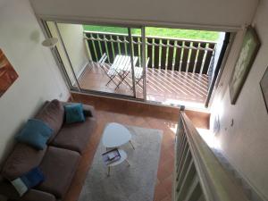 uma sala de estar com um sofá e uma varanda em Appartement LARUNS 2 à 4 personnes em Laruns