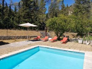 LʼEscarèneにあるAppartement de 3 chambres avec piscine partagee jardin amenage et wifi a Berre les Alpesのスイミングプール(椅子2脚、パラソル付)