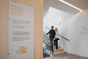 Ein Mann und eine Frau gehen die Treppe hinunter in der Unterkunft Hotel OLDINN in Český Krumlov