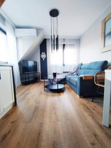 sala de estar con sofá azul y mesa en Apartament Klimatyzowany Teren Ośrodka Sun&Snow Białka Tatrzańska, en Białka Tatrzanska