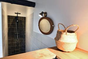 a bathroom with a mirror and a basket on a counter at Le Bruit de l'Eau (Chambre Cosy) in Labeaume