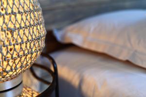 a lamp on a table next to a bed at Le Bruit de l'Eau (Chambre Cosy) in Labeaume