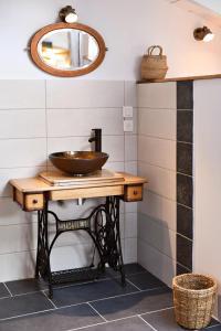 a bathroom with a wooden sink and a mirror at Le Bruit de l'Eau (Chambre Cosy) in Labeaume