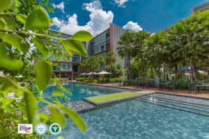 a swimming pool in front of a building at Aisana Hotel Korat in Nakhon Ratchasima