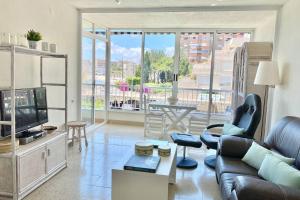Una sala de estar con un sofá y un televisor. en Tahití apartamento primera línea de PLaya Muchavista, Wifi, parking, en El Campello