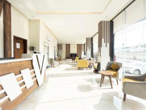 vestíbulo de un edificio con sillas y mesas en The Palace Hotel Suites - Al Badea en Abha