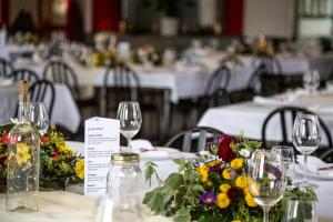 a group of tables with glasses and flowers on them at Tignousa logement de groupes et individuels in Saint-Luc