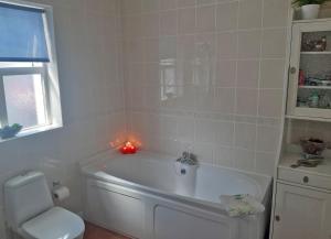 a bathroom with a white tub with a candle in it at Primrose Cottage in Kinnitty +15 photos