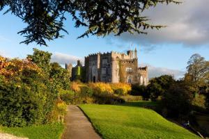 a castle sitting on top of a lush green field at Primrose Cottage in Kinnitty