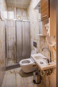 a bathroom with a shower and a toilet and a sink at Grand Balyan Hotel & Restaurant in Istanbul