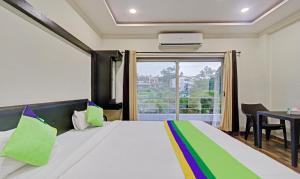 Кровать или кровати в номере Treebo Trend Paradise Inn Panchgani