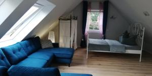 a living room with a blue couch and a bed at Apartment bei Paulchen in Schneverdingen