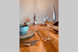 a glass of wine sitting on a wooden table at Schönes ruhiges App mit Panoramablick auf den Harz in Braunlage +18 photos