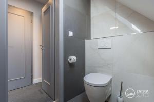 a bathroom with a white toilet in a room at TATRA SUITES Boutique Suites Deforte Star View 301 in Poprad +5 photos