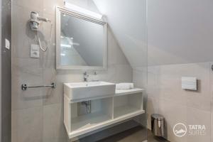 a bathroom with a sink and a mirror at TATRA SUITES Boutique Suites Deforte Star View 301 in Poprad