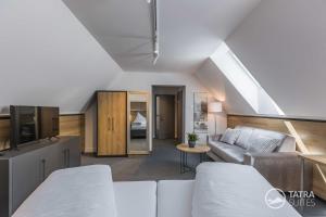 een woonkamer met een bank en een tafel bij TATRA SUITES Boutique Suites Deforte Star View 301 in Poprad
