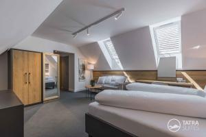 a bedroom with two beds and a living room at TATRA SUITES Boutique Suites Deforte Star View 301 in Poprad