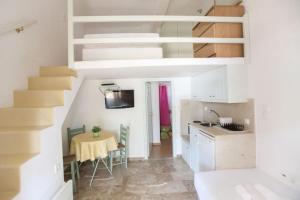 a kitchen with a table and a staircase in a room at kyma studios in Livadi